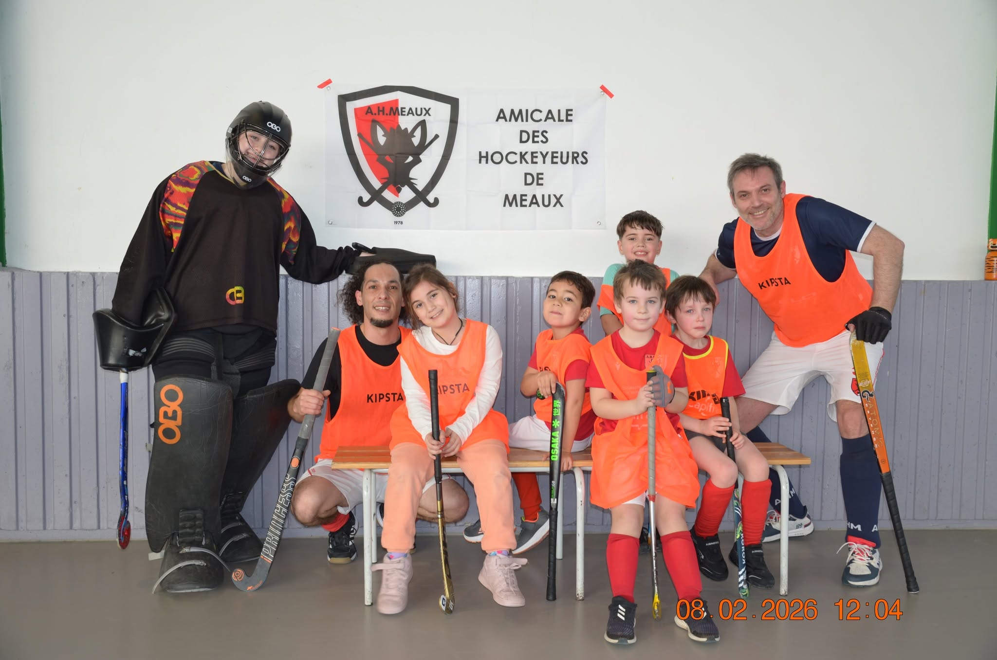Groupe de jeunes et adultes AHM devant la bannière du club lors de la journée club