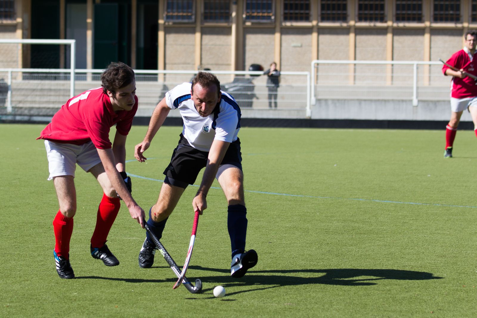 Joueurs de l'AHM et du HSCSM disputant la balle au milieu de terrain sous le regard de l'arbitre