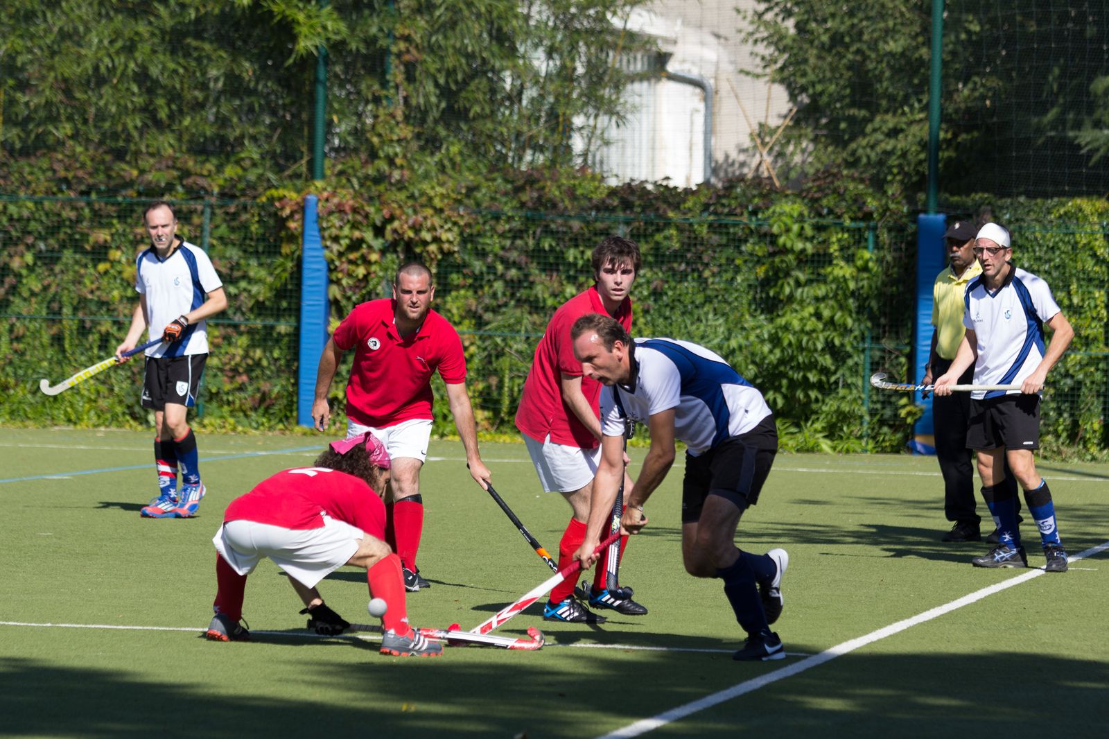 Regroupement de joueurs de l'AHM et du HSCSM autour de la balle sous le regard de l'arbitre