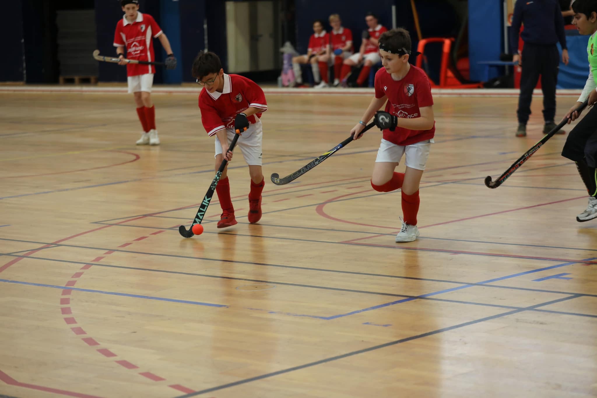 Jeunes joueurs AHM en duel lors d'un match de hockey en salle